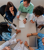 Doctors and patients sitting at a table.